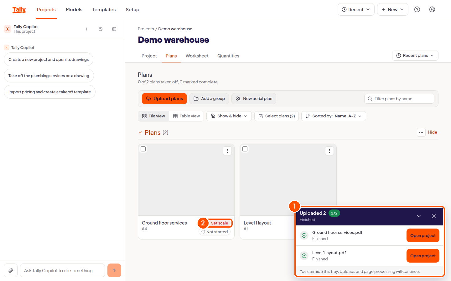 The plans page with the upload progress tray showing two finished imports